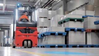 Ya sea hacia adelante o hacia atrás: La cabina ergonómica minimiza el esfuerzo físico del conductor. Un conductor de carretilla avanza hacia atrás por el almacén con una carretilla eléctrica de Linde.